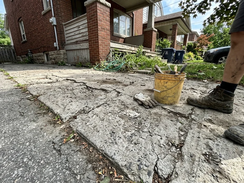 Cracked and salt-spalled driveway before replacement