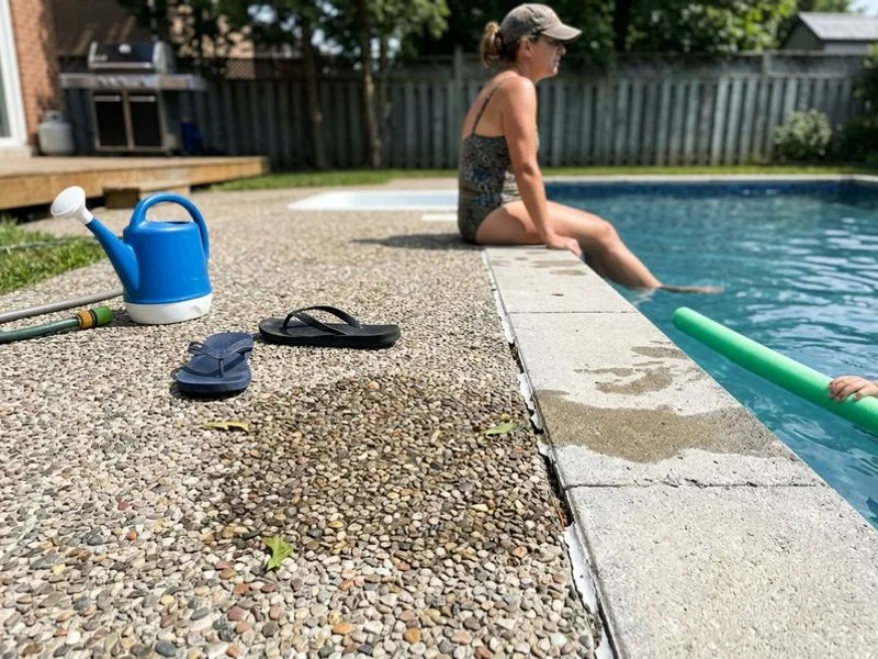 Exposed-aggregate pool deck surface beside the coping