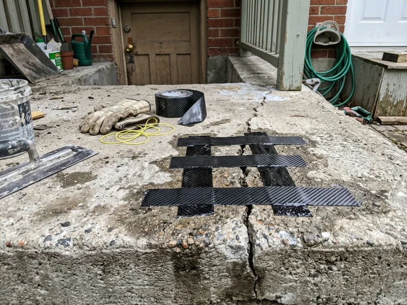 Carbon-fibre stitching strips epoxied across a structural porch crack