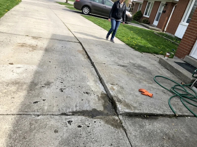 Wide structural crack across a driveway slab before repair