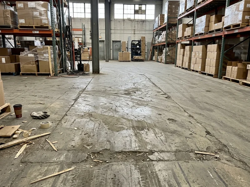 Worn commercial floor with spalled joints before replacement