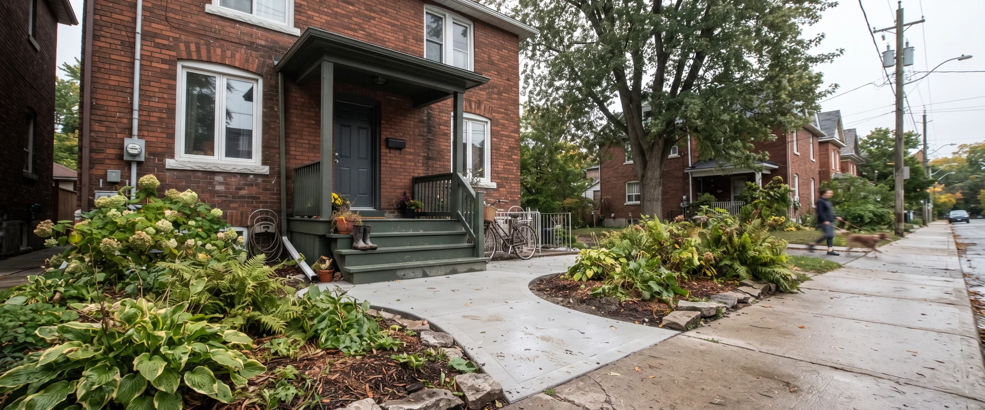 New concrete walkway leading from the sidewalk to the front steps of a Toronto home