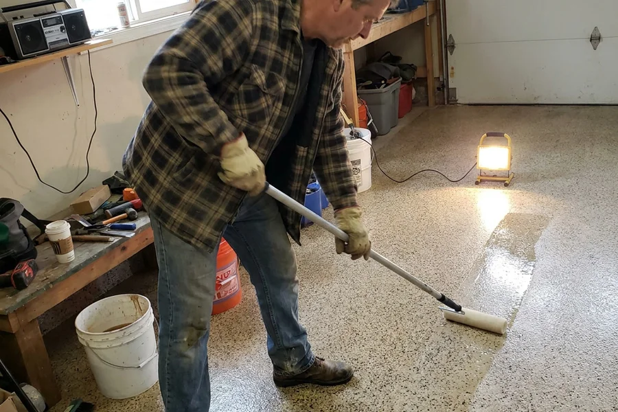 Installer rolling a clear polyaspartic topcoat across prepared decorative concrete